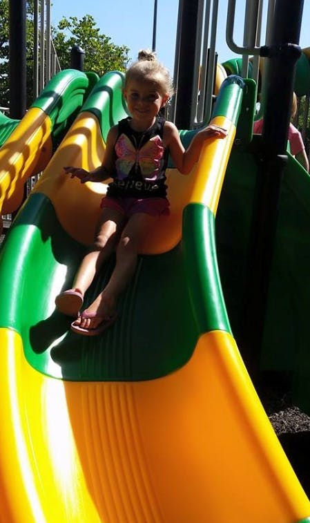 Child sitting on a playground slide