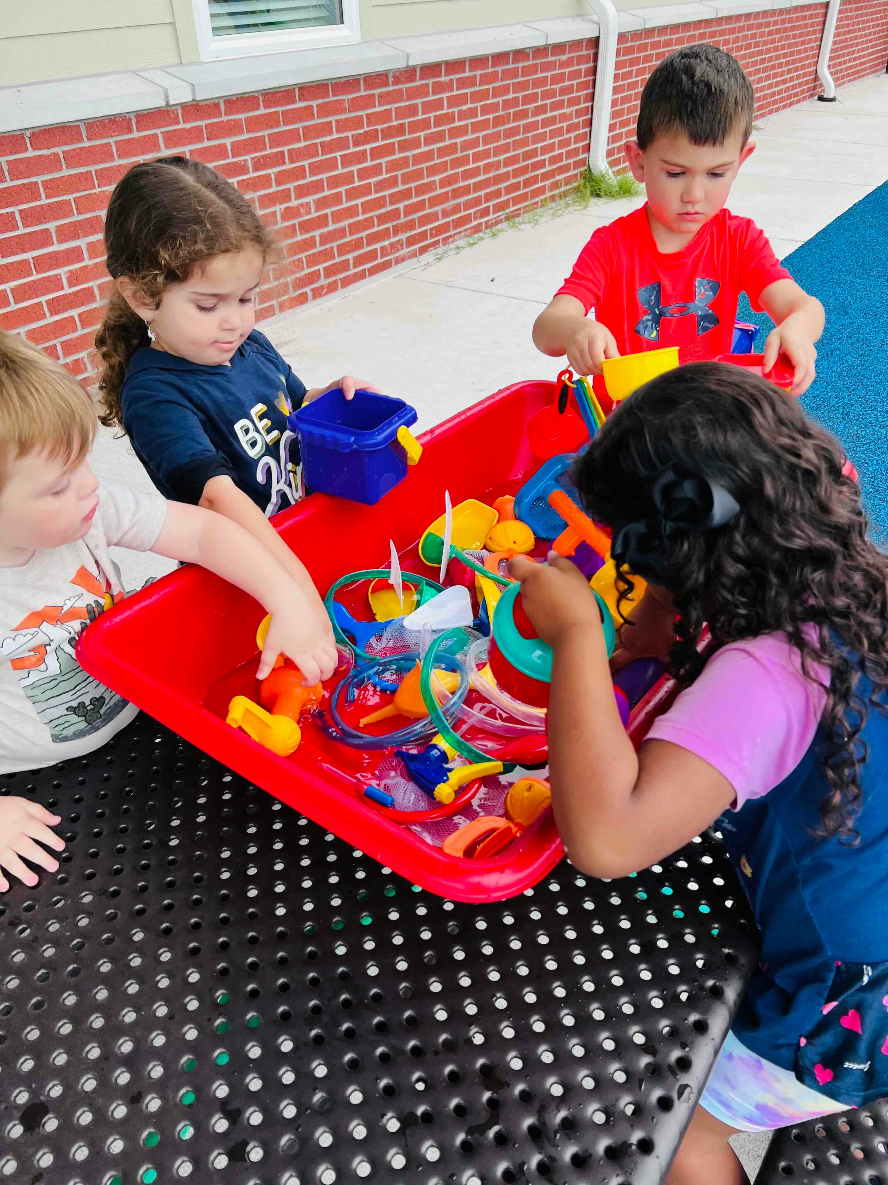 Children playing with toys in a red bin