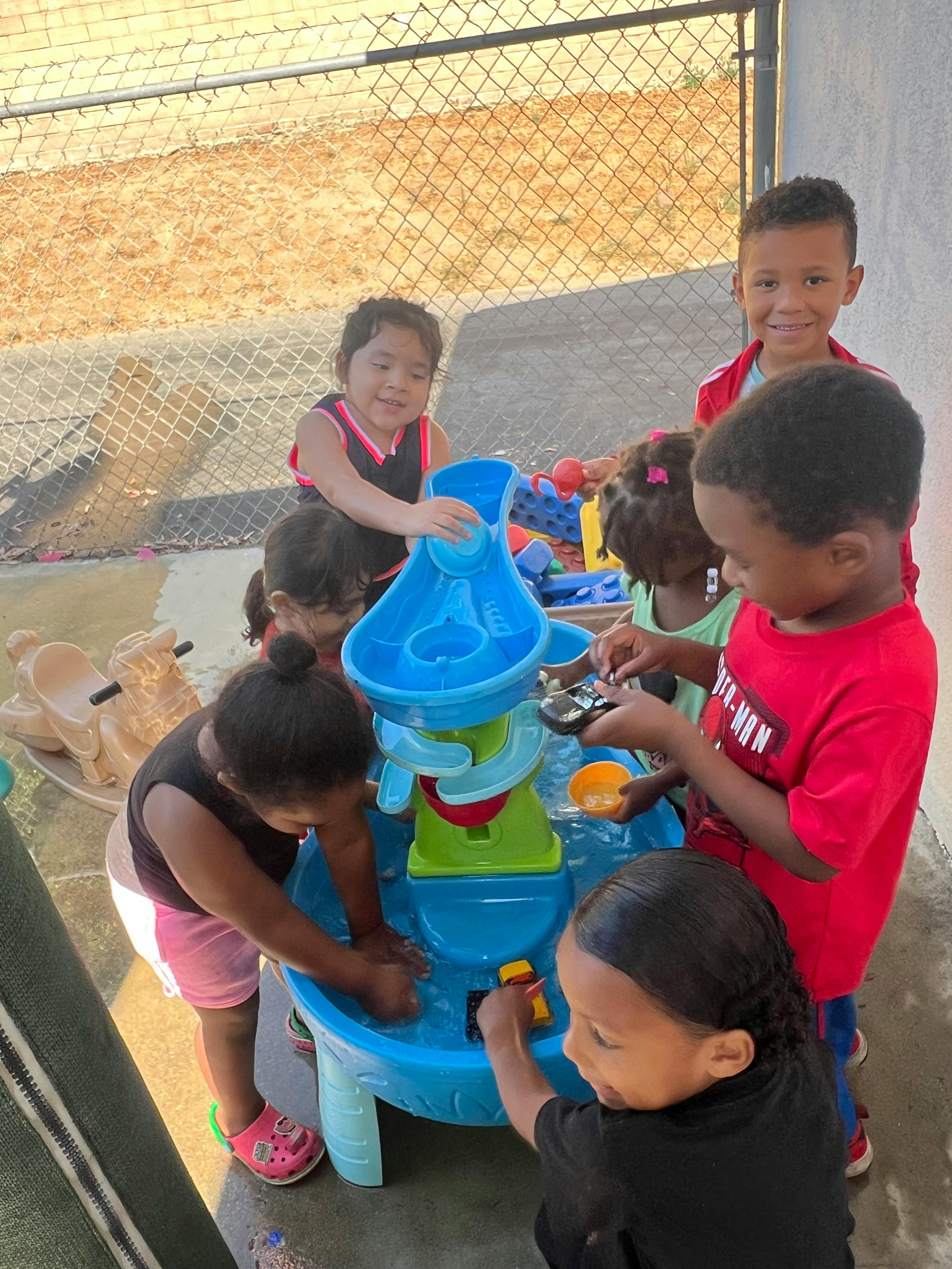 Children playing with a water table outdoors