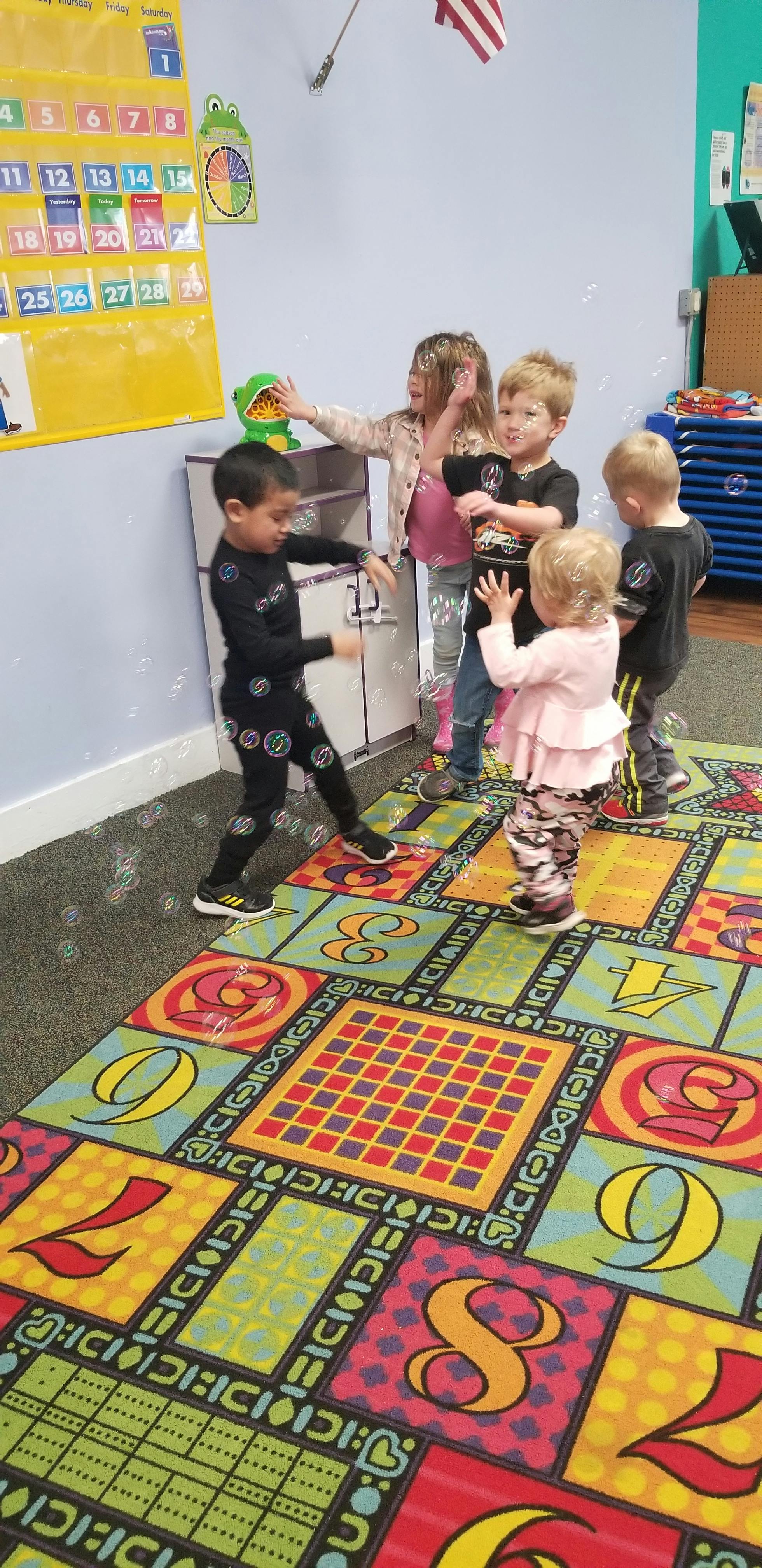 Children playing with bubbles in a classroom