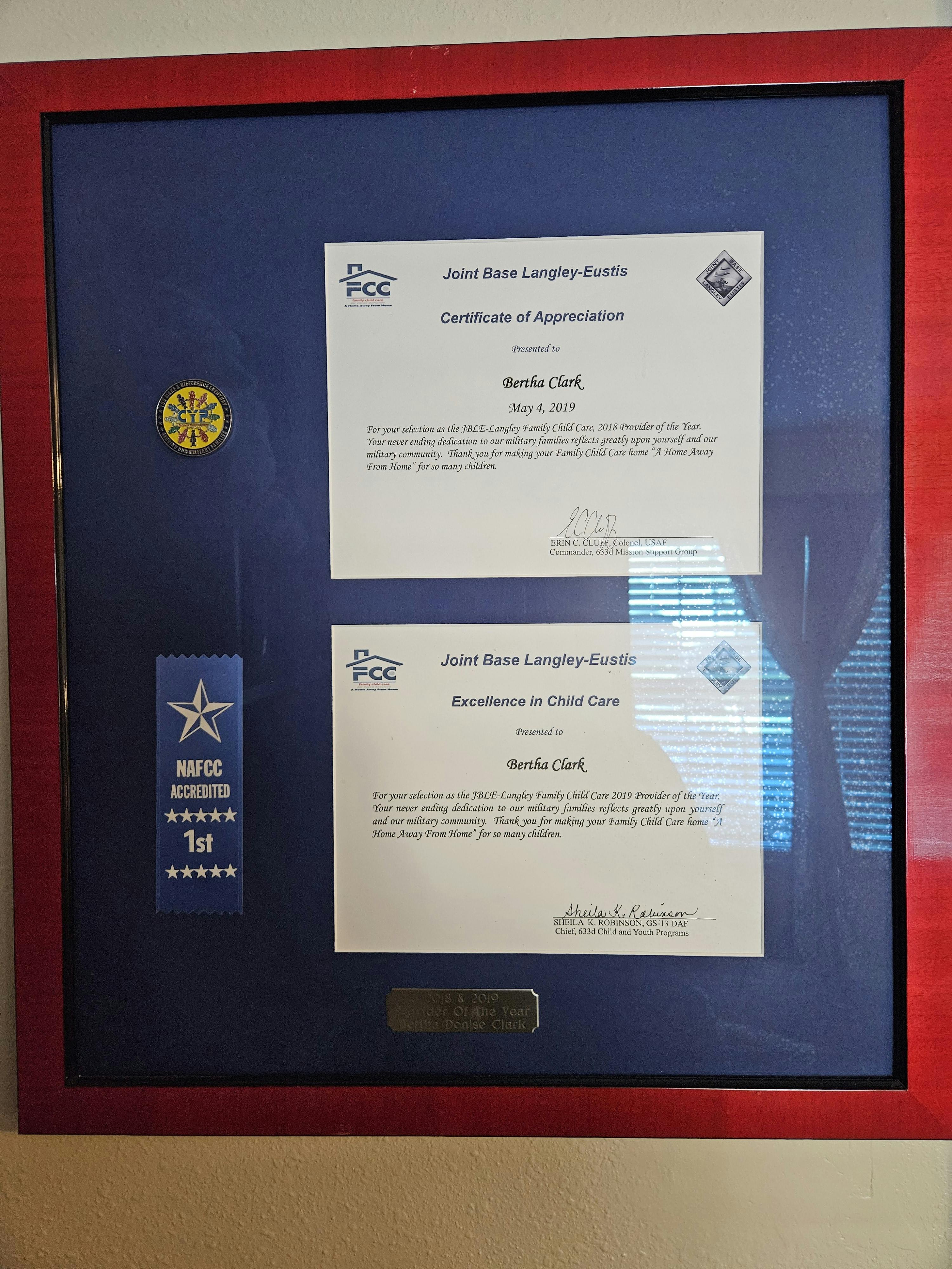 Framed certificates and a blue ribbon with a star