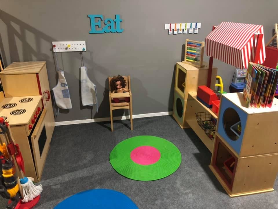 Playroom with toy kitchen, market stand, and high chair