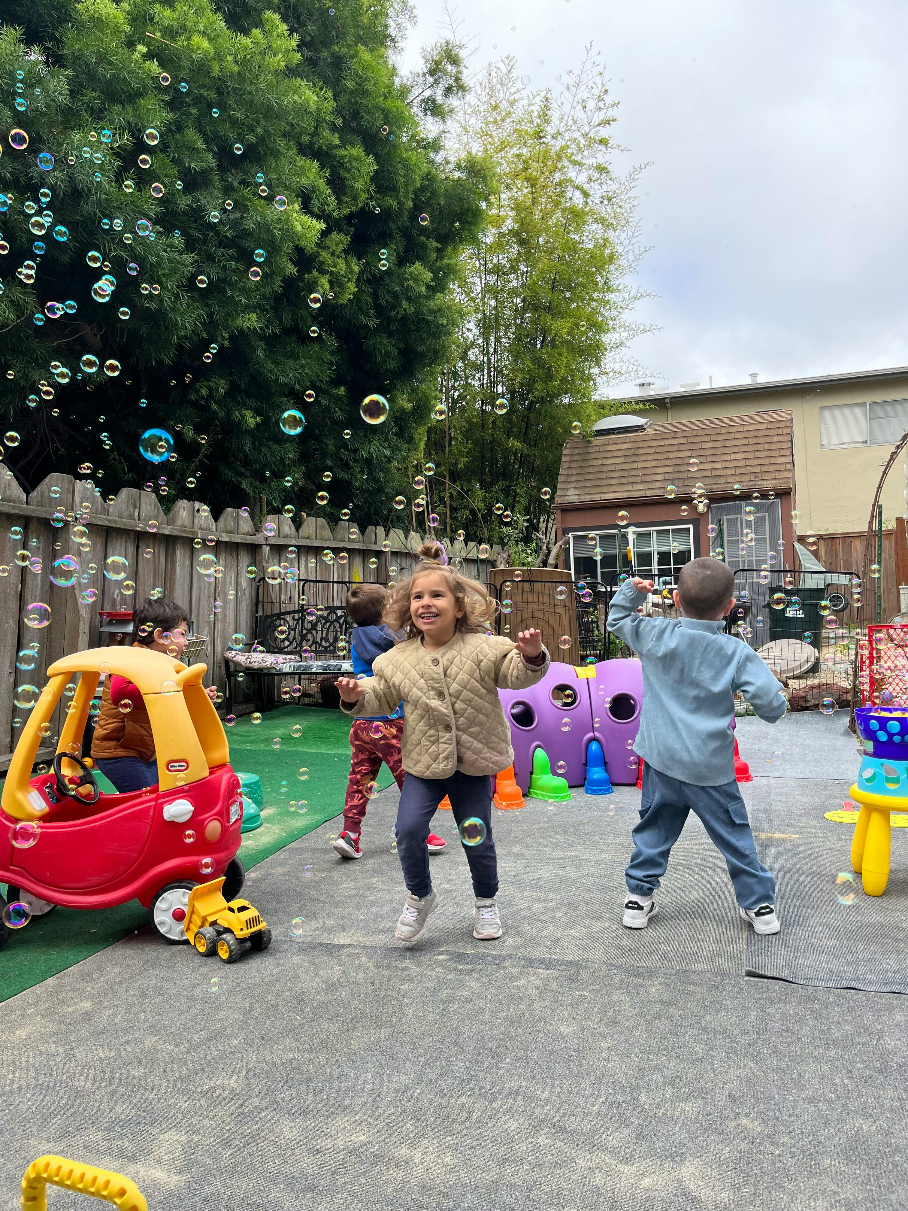 Children playing outdoors with bubbles