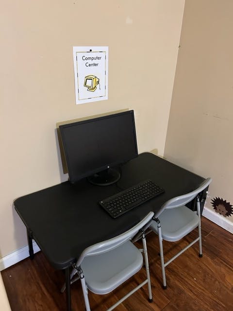 Computer center sign above a desk with a monitor and keyboard