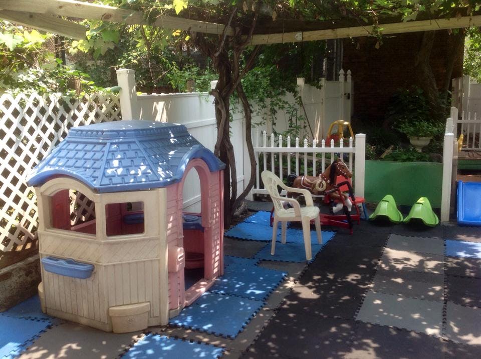 Playhouse and outdoor play area with white fence