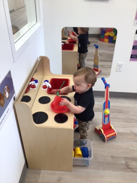 Child playing with a toy kitchen set