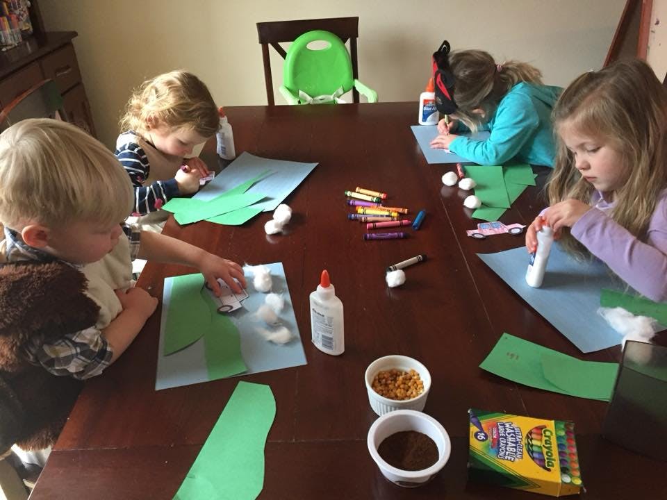 Four children doing crafts at a table