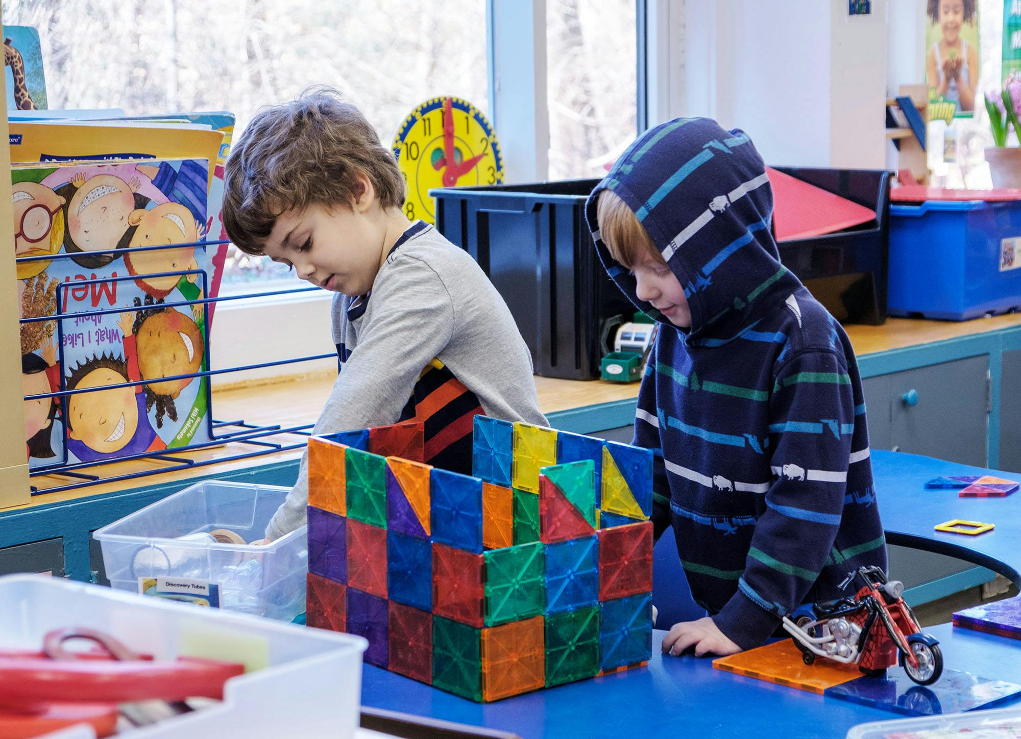 Two children playing with colorful magnetic blocks