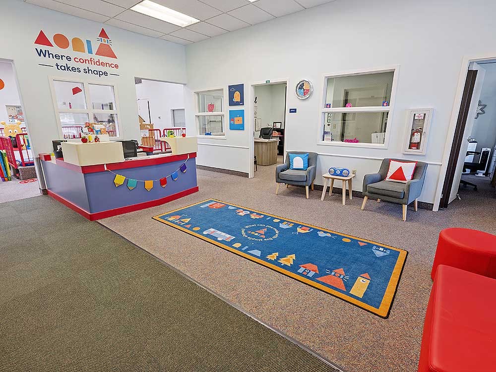 Reception area of a children's learning center with a counter and chairs