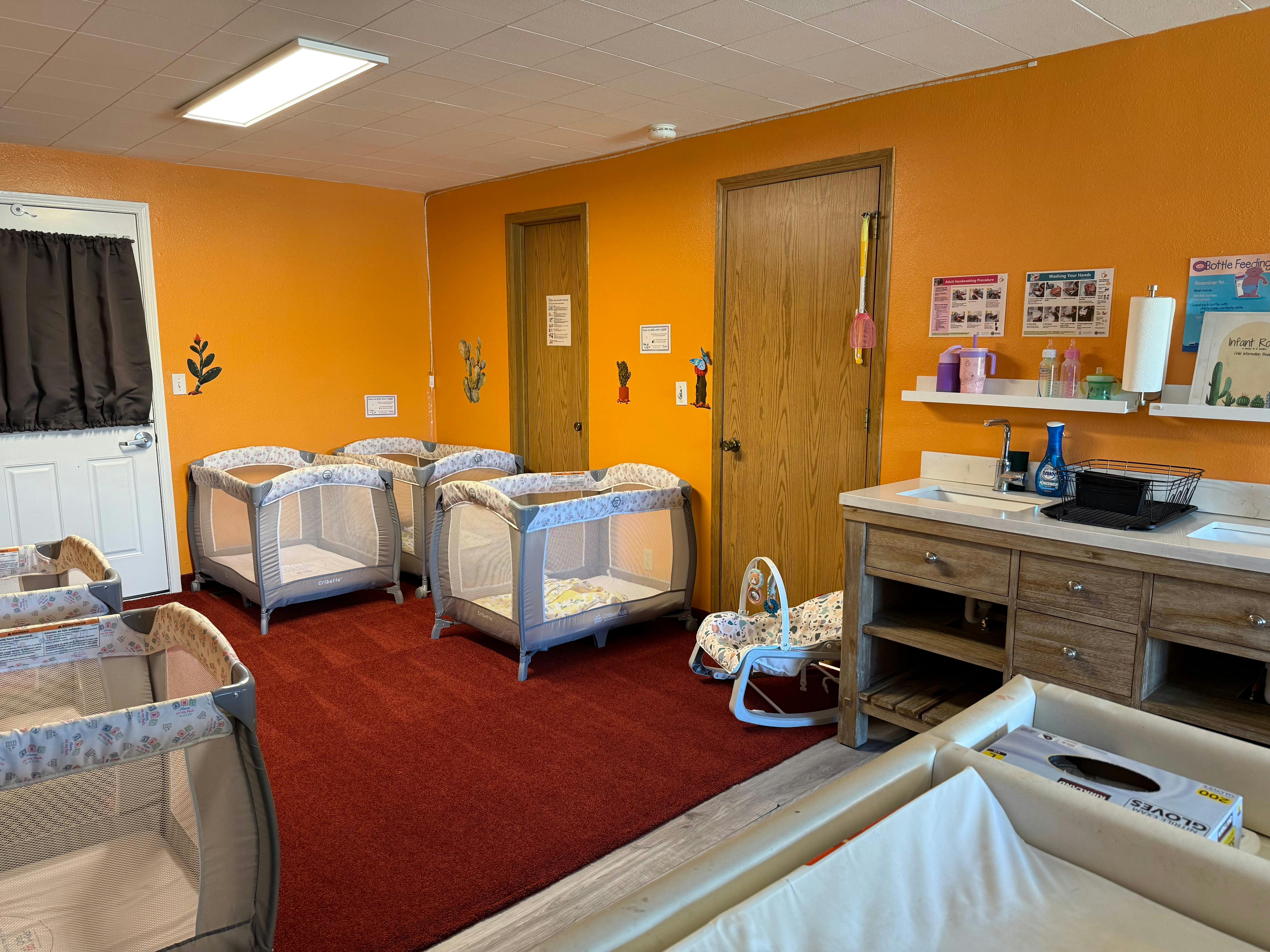 Nursery room with multiple cribs and changing stations