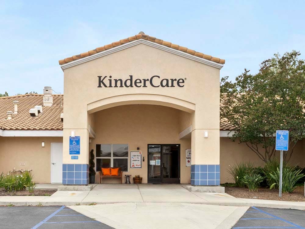 Entrance to a KinderCare building with an archway and sign above