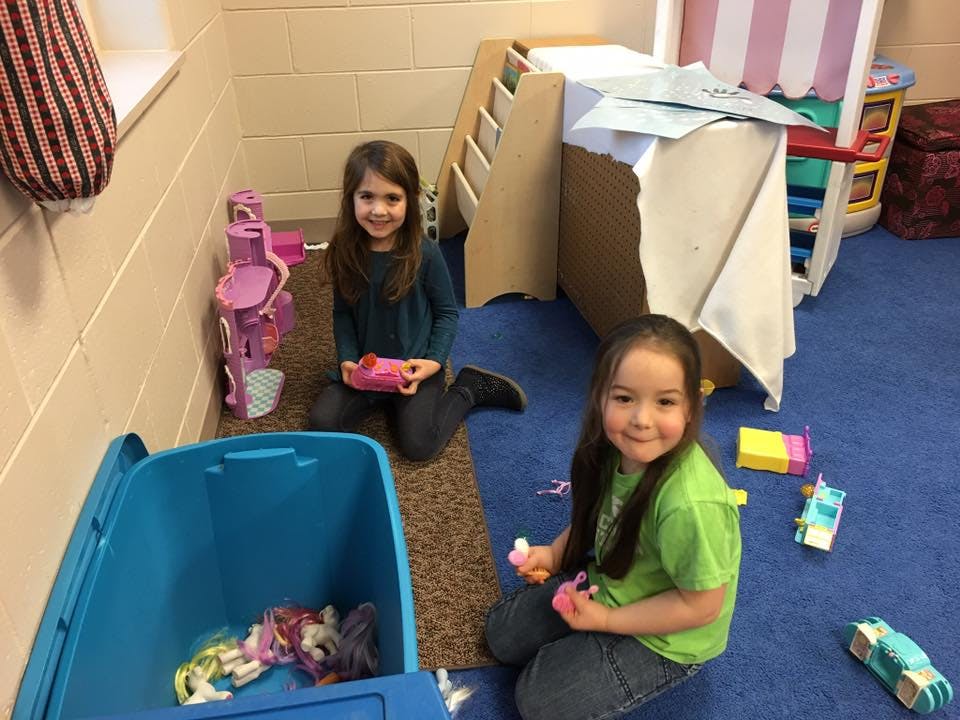 Two children playing with toys on the floor