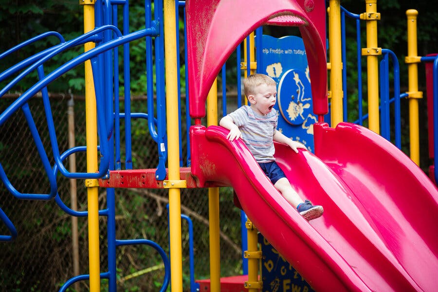 Child on a red slide at a playground