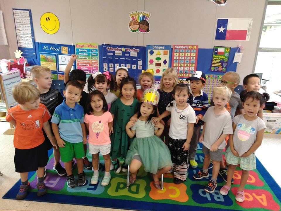 Group of children standing in a classroom