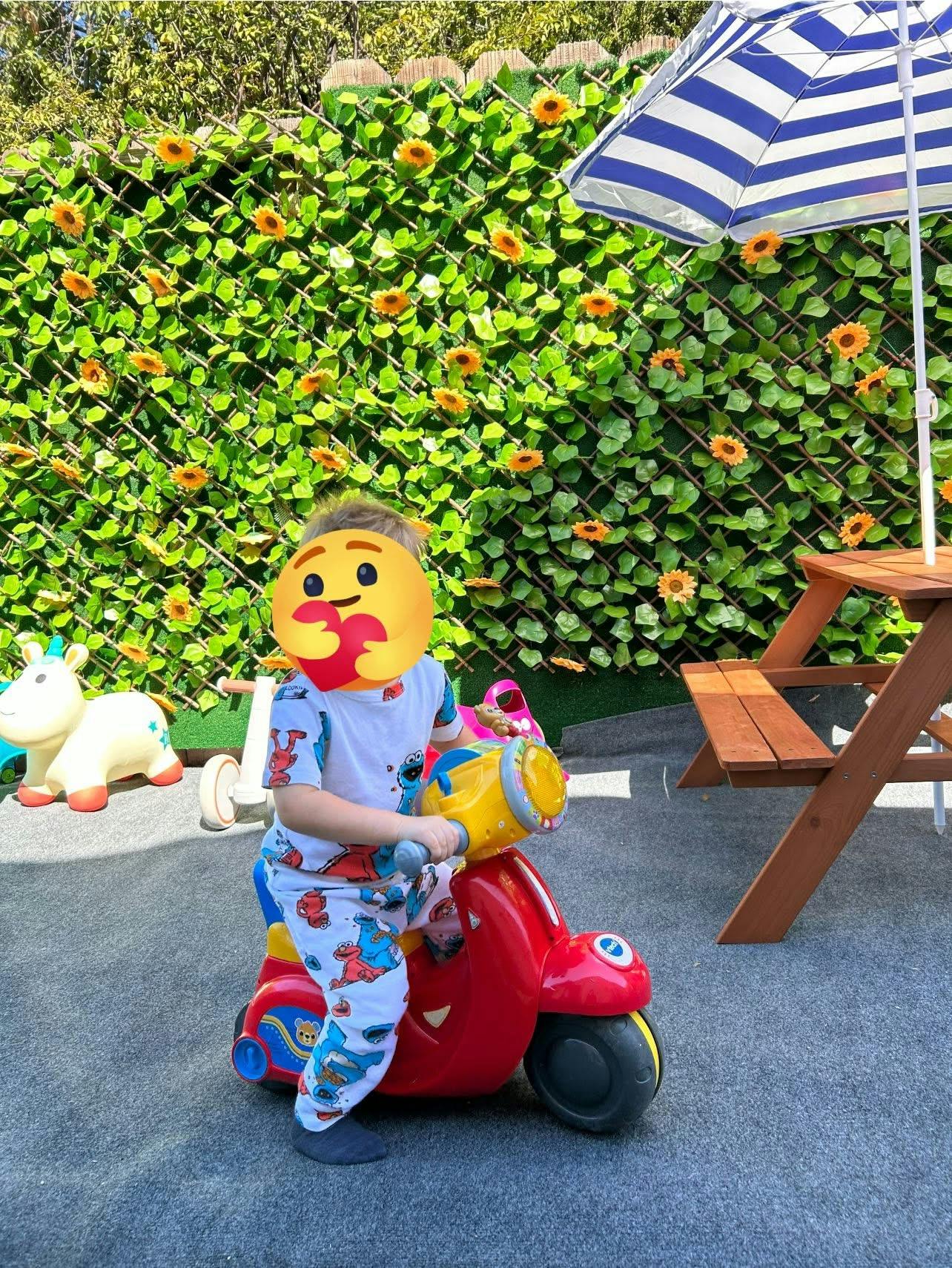 Child on a red toy scooter