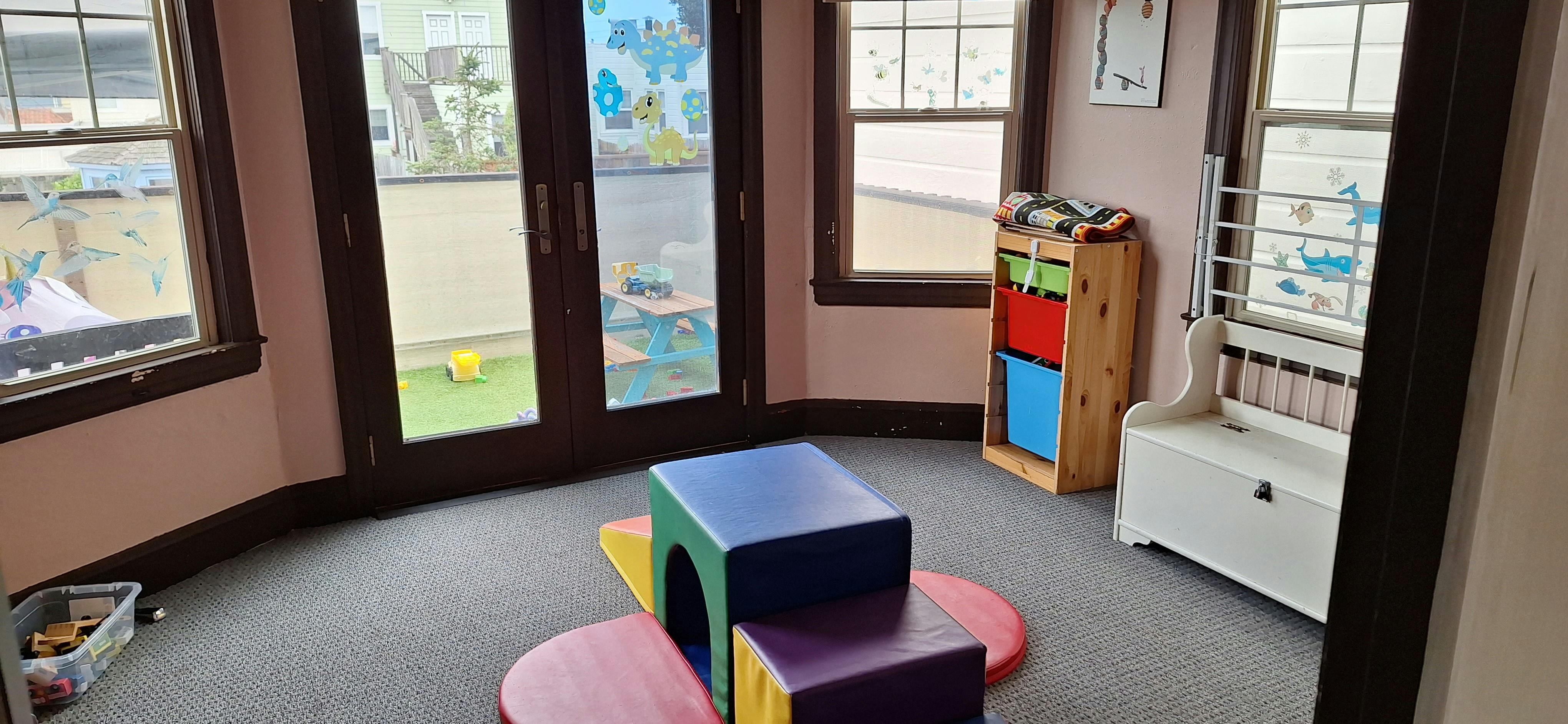 Playroom with colorful soft play equipment and storage shelves