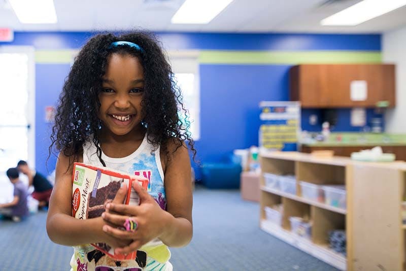 Child holding a book in a classroom