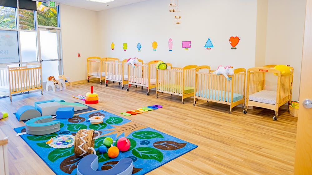 Nursery room with multiple cribs and play mats