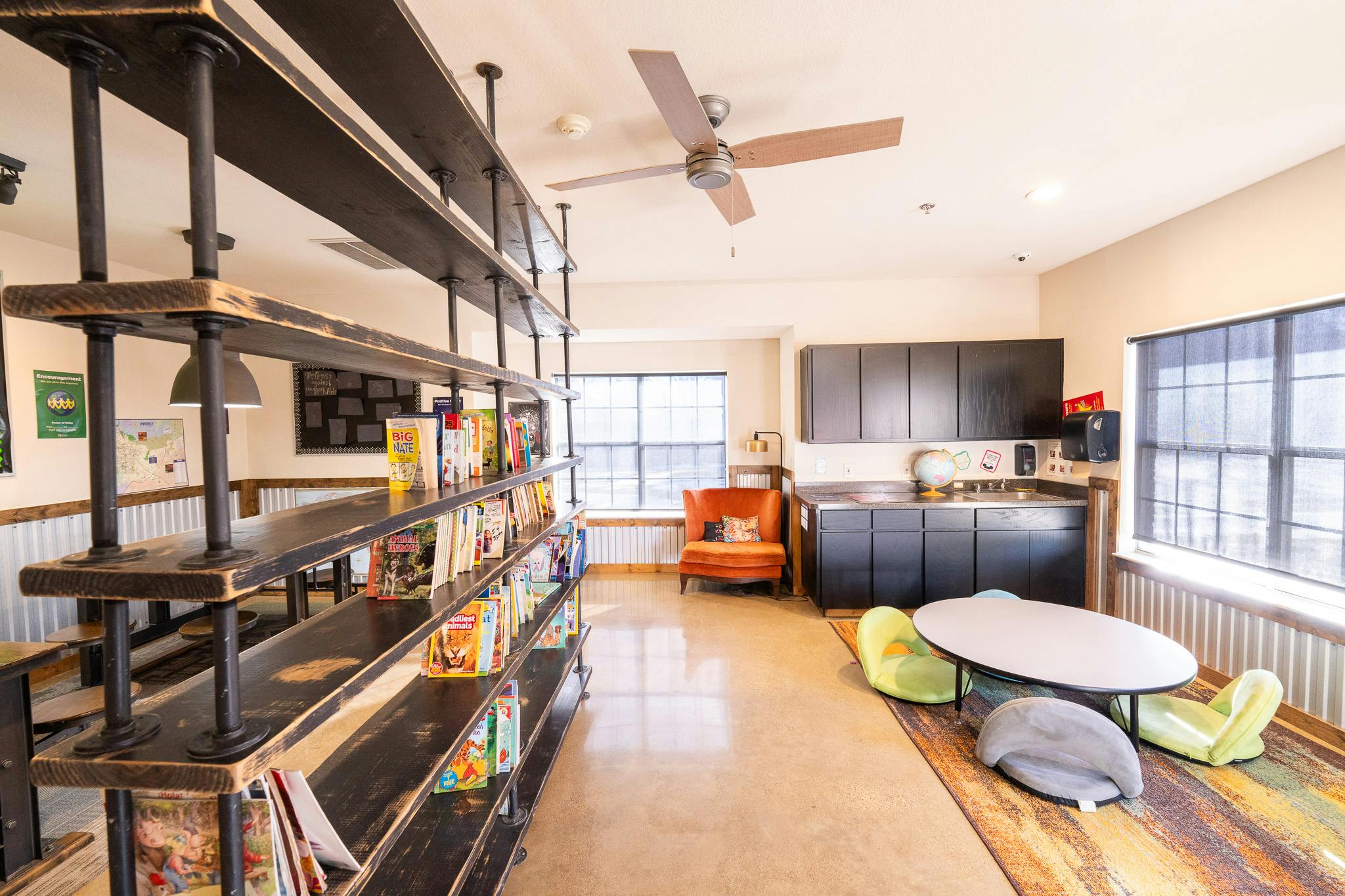 Bookshelf in a room with a round table and floor seating