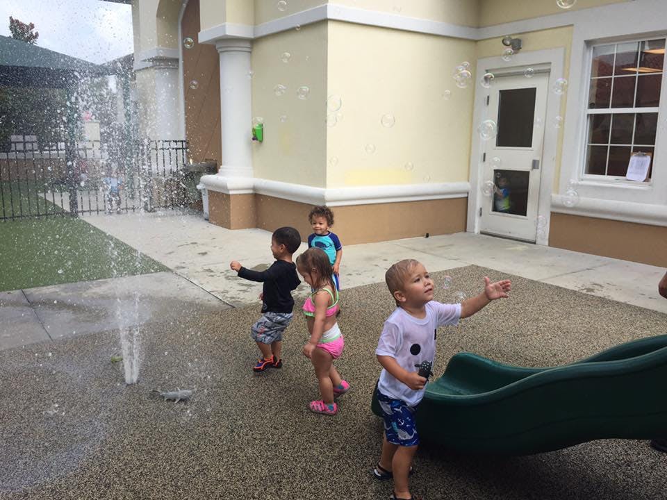 Children playing with water and bubbles outdoors