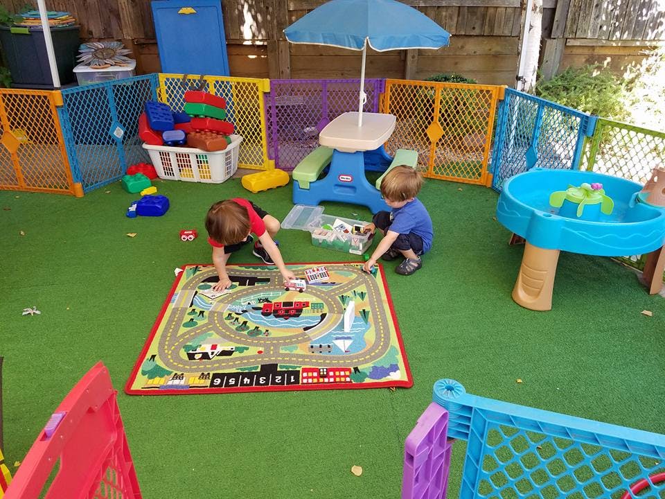 Two children playing with toys on a train rug