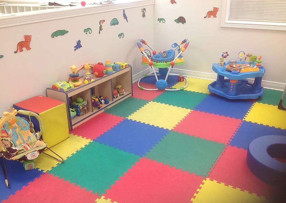Playroom with colorful floor mats, toys, and baby activity centers