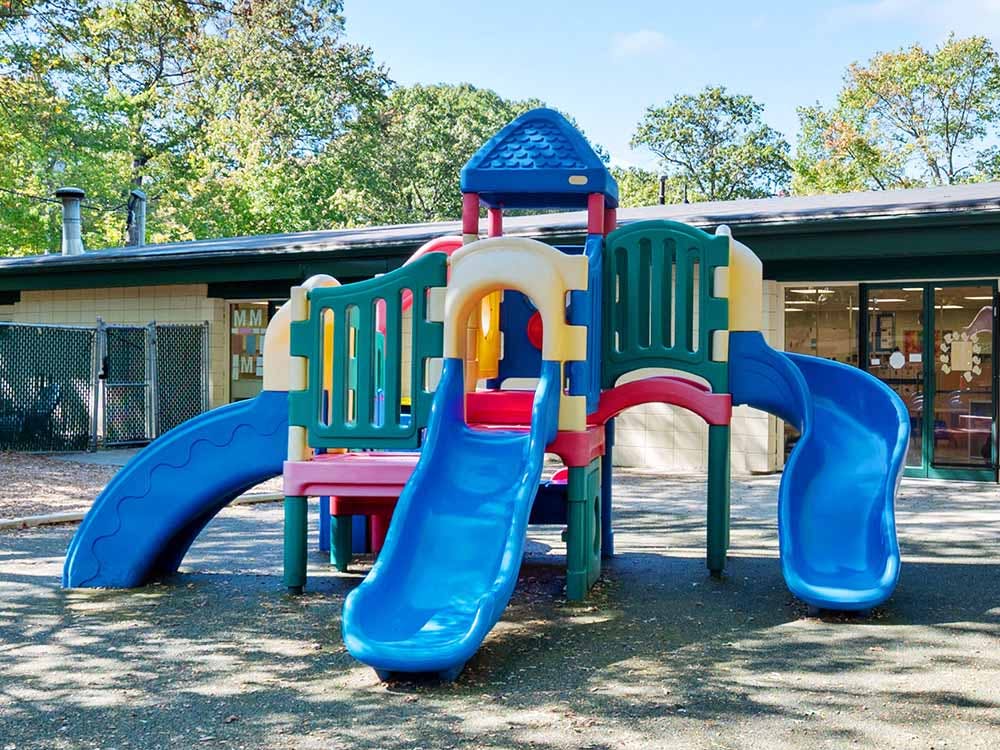Colorful playground structure with multiple slides outside a building