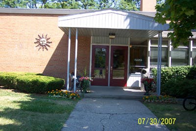 Building entrance with red doors and a sun decoration on the brick wall