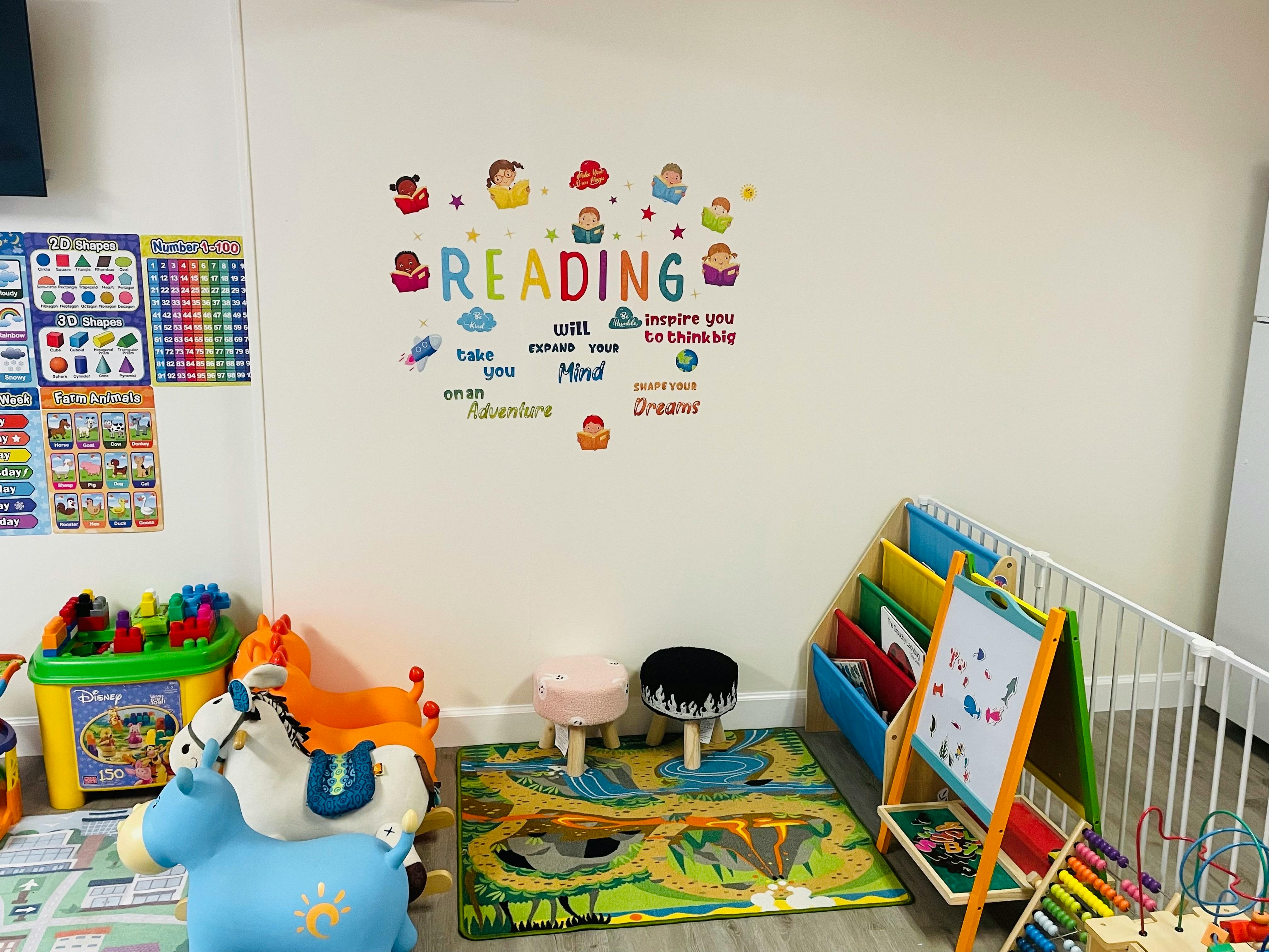 Reading wall decal with children's books and learning toys in a classroom area