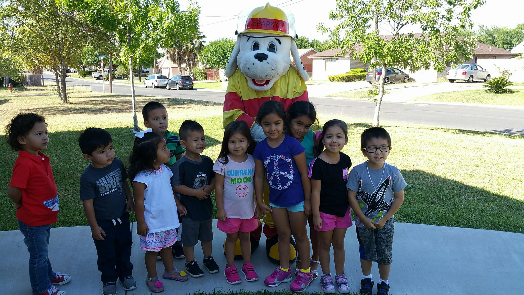 Children posing with a person in a dog mascot costume