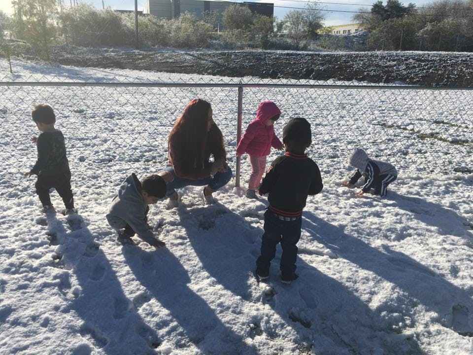 Adult and children playing in snow