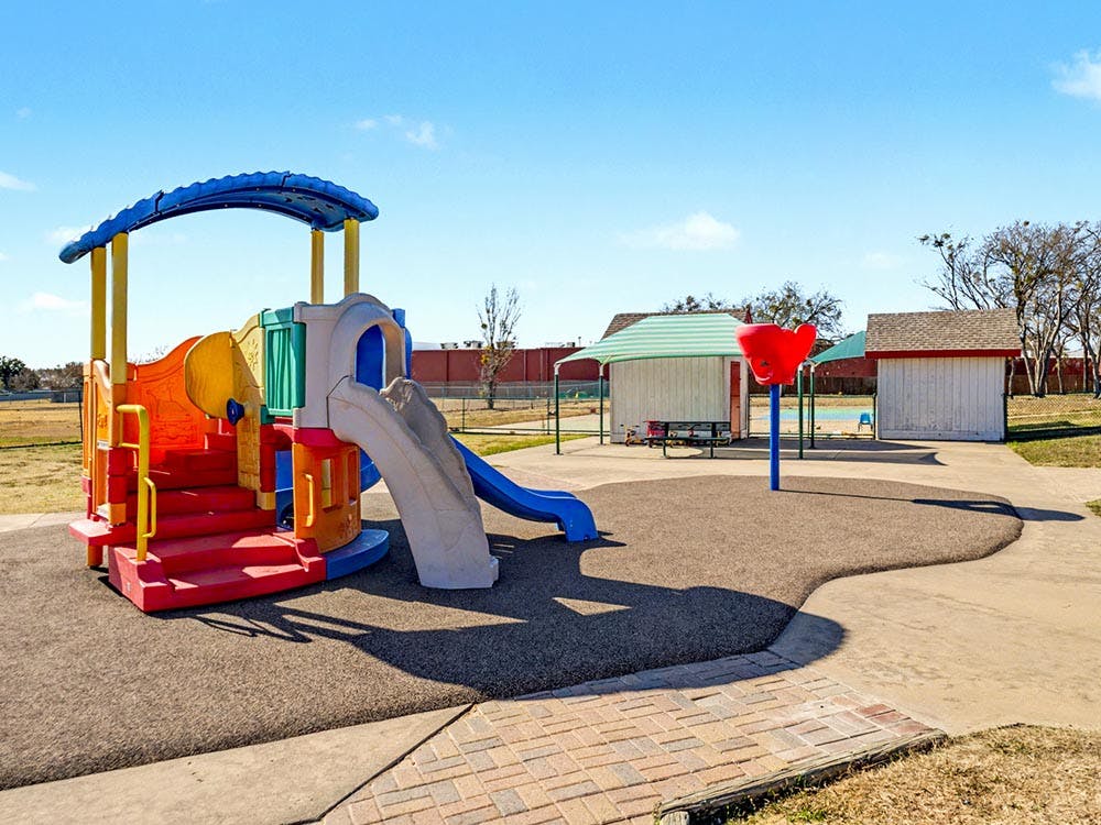 Colorful playground structure with slides and steps on rubber surfacing