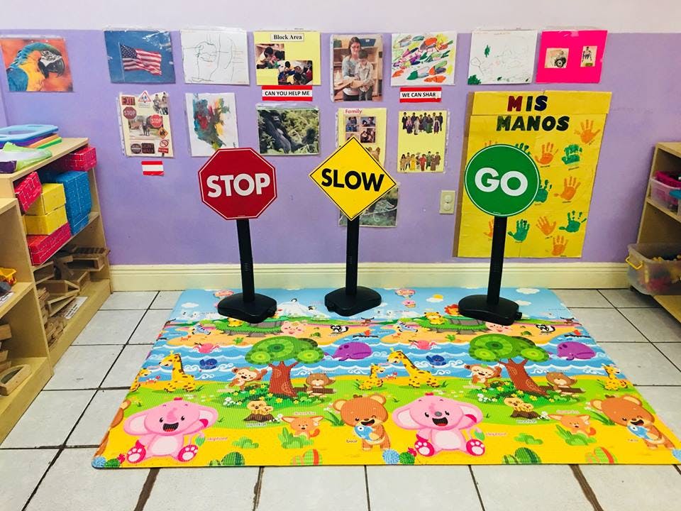 Playroom with a colorful mat and three traffic signs: stop, slow, and go