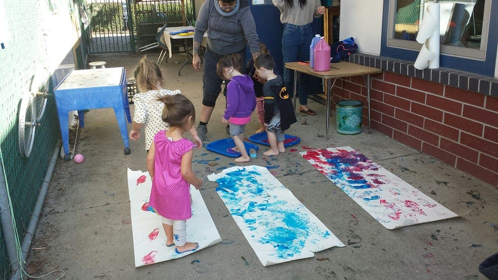Children making art with their feet on paper