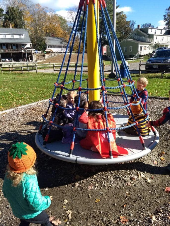 Children playing on a merry-go-round at a playground