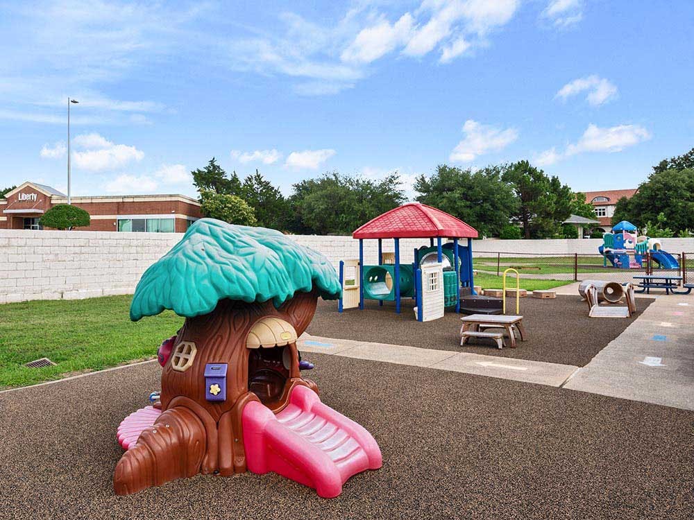 A colorful outdoor playground with a treehouse structure and slides