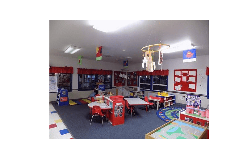 Classroom with small tables and chairs, and play areas