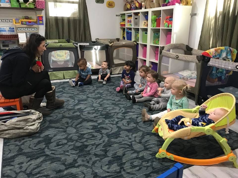 Adult and children sitting on floor in a room