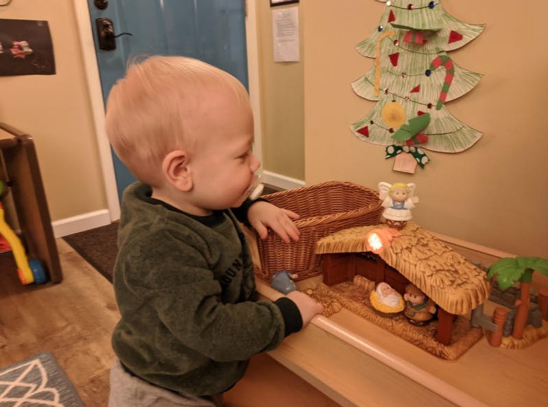 Child looking at a nativity scene