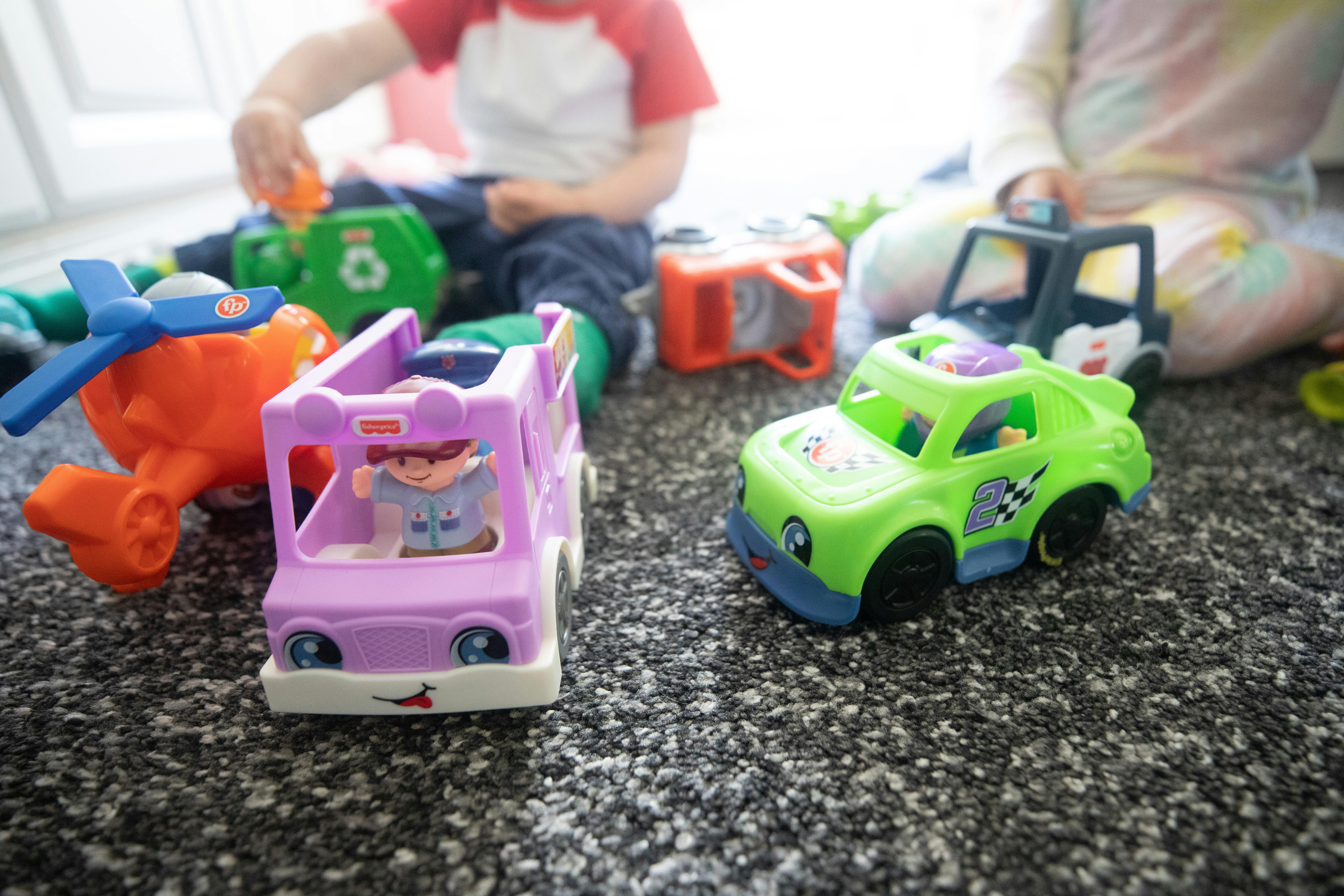 Child playing with toy cars and airplane on a carpet