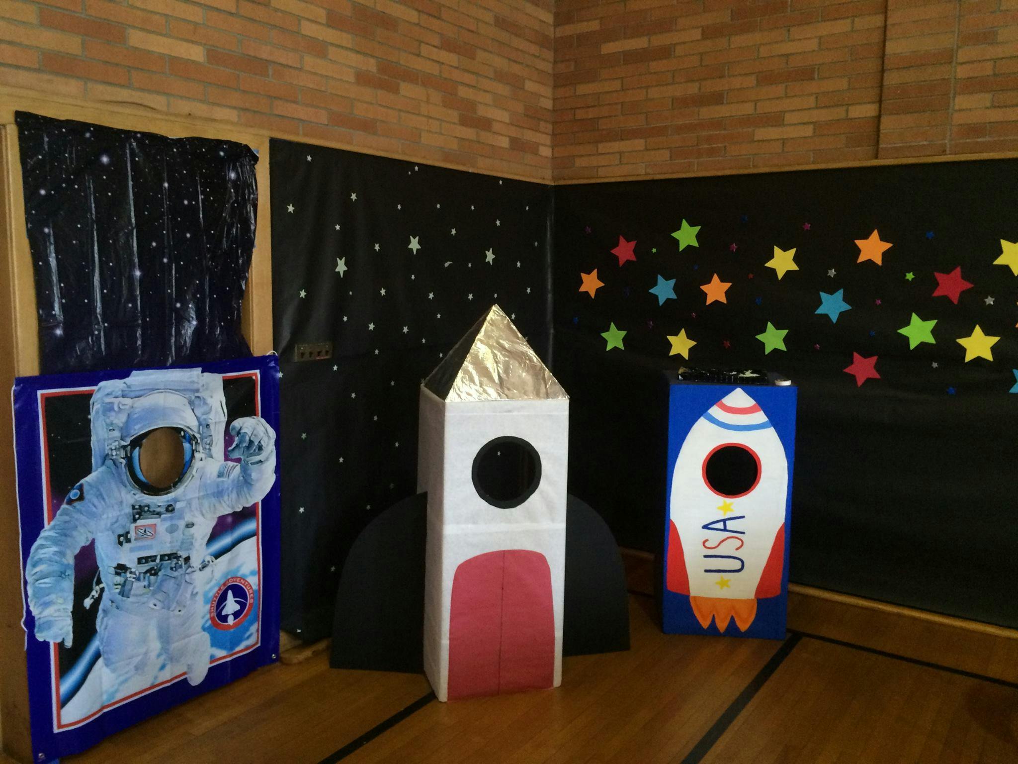 Space-themed photo booth props with astronaut cutout and rockets