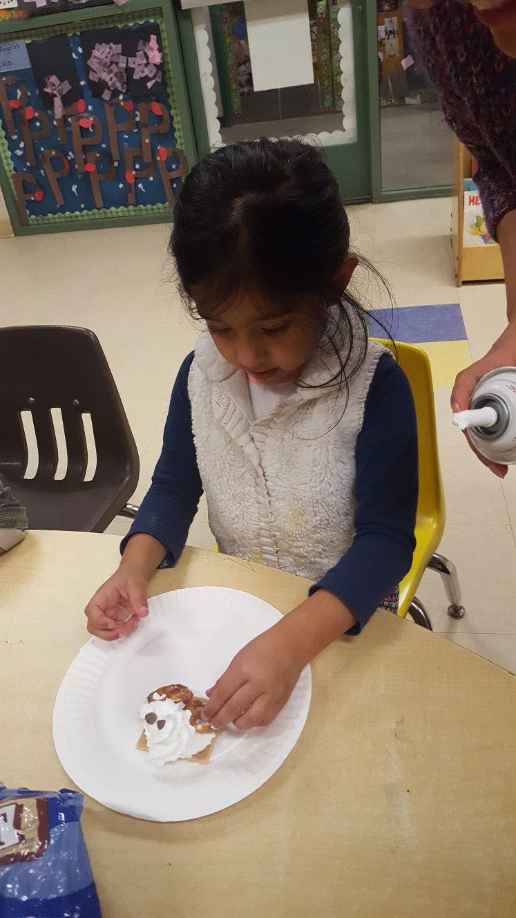 Child decorating a dessert on a plate