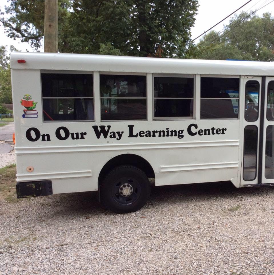 White bus with "On Our Way Learning Center" on its side