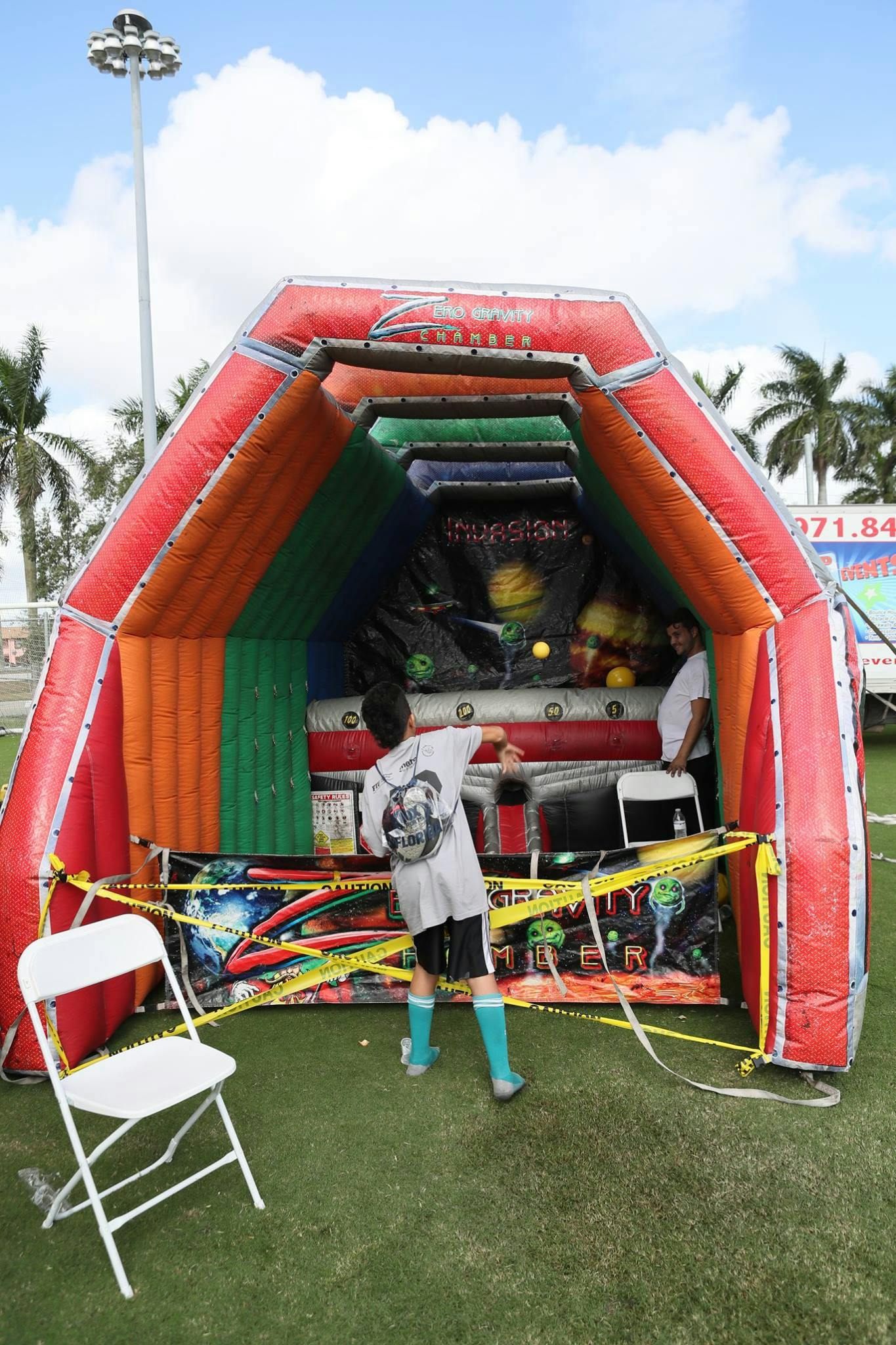 Child playing an inflatable game with another person inside