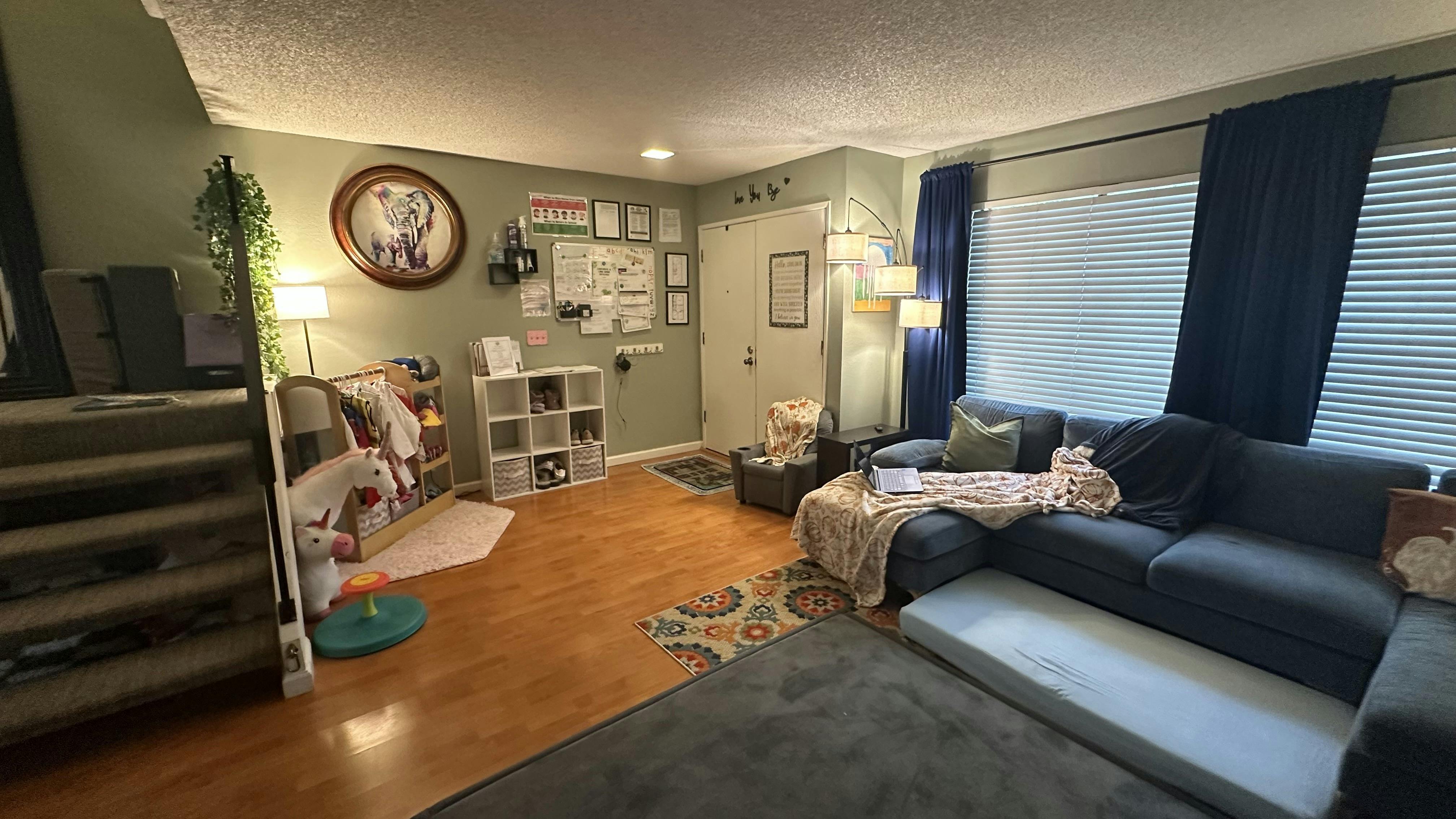 Living room with a blue sectional sofa, wooden floor, and light green walls