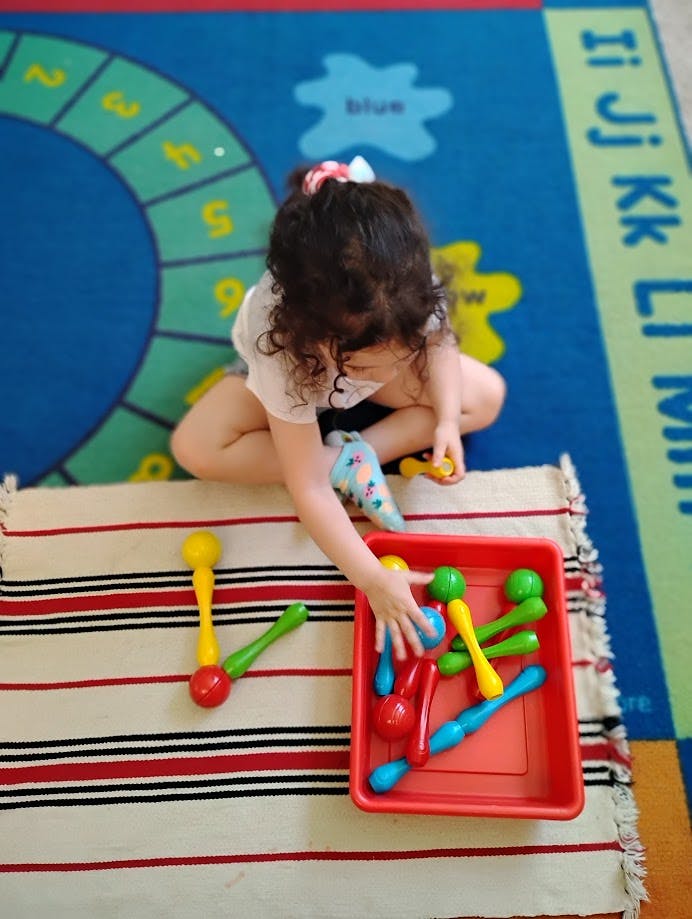 Child playing with colorful toys on a rug