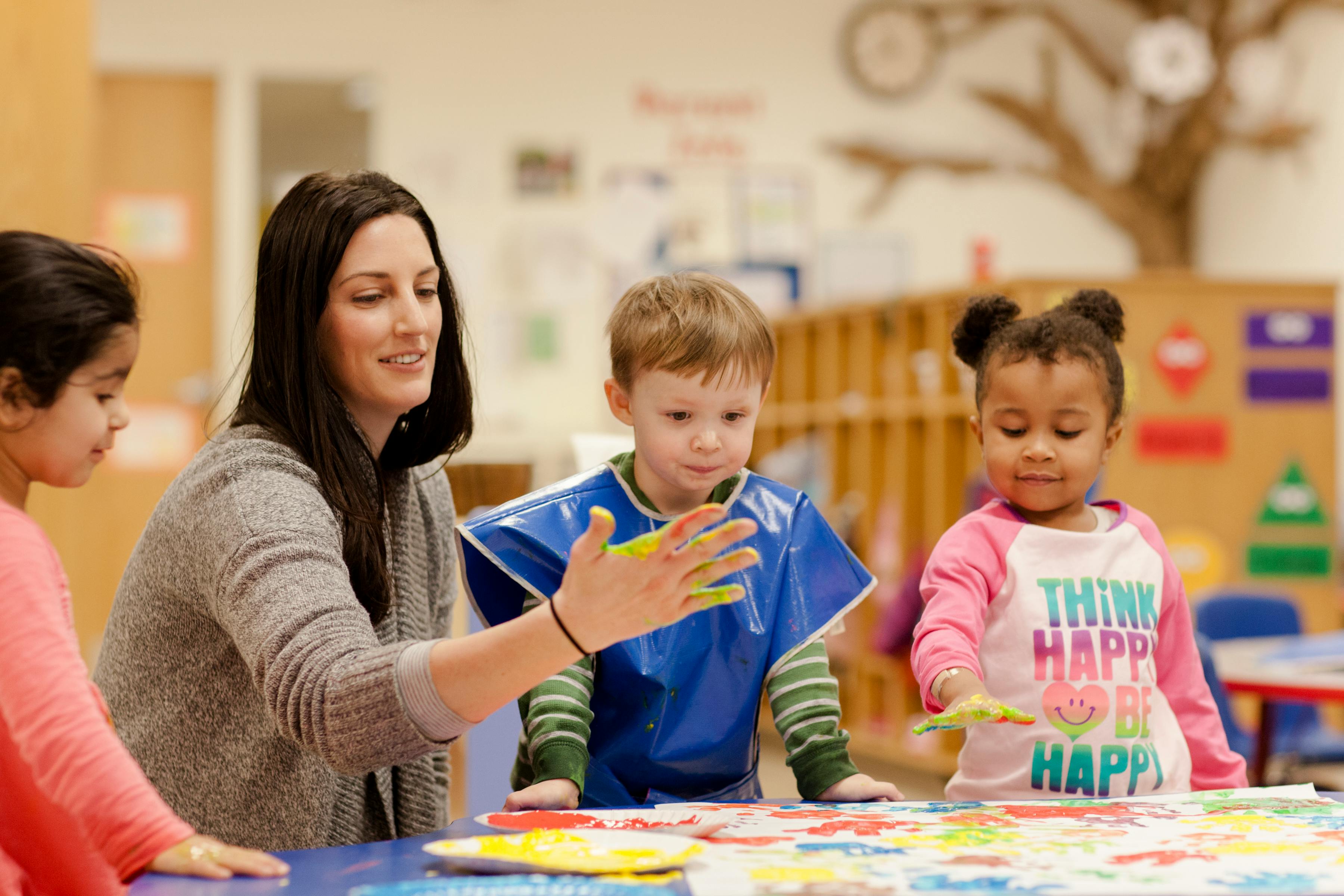 Adult and two children painting at a table