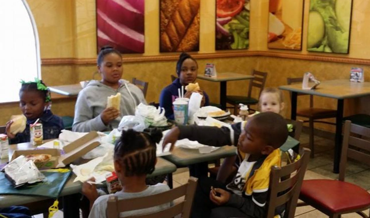 People and children eating at tables in a restaurant