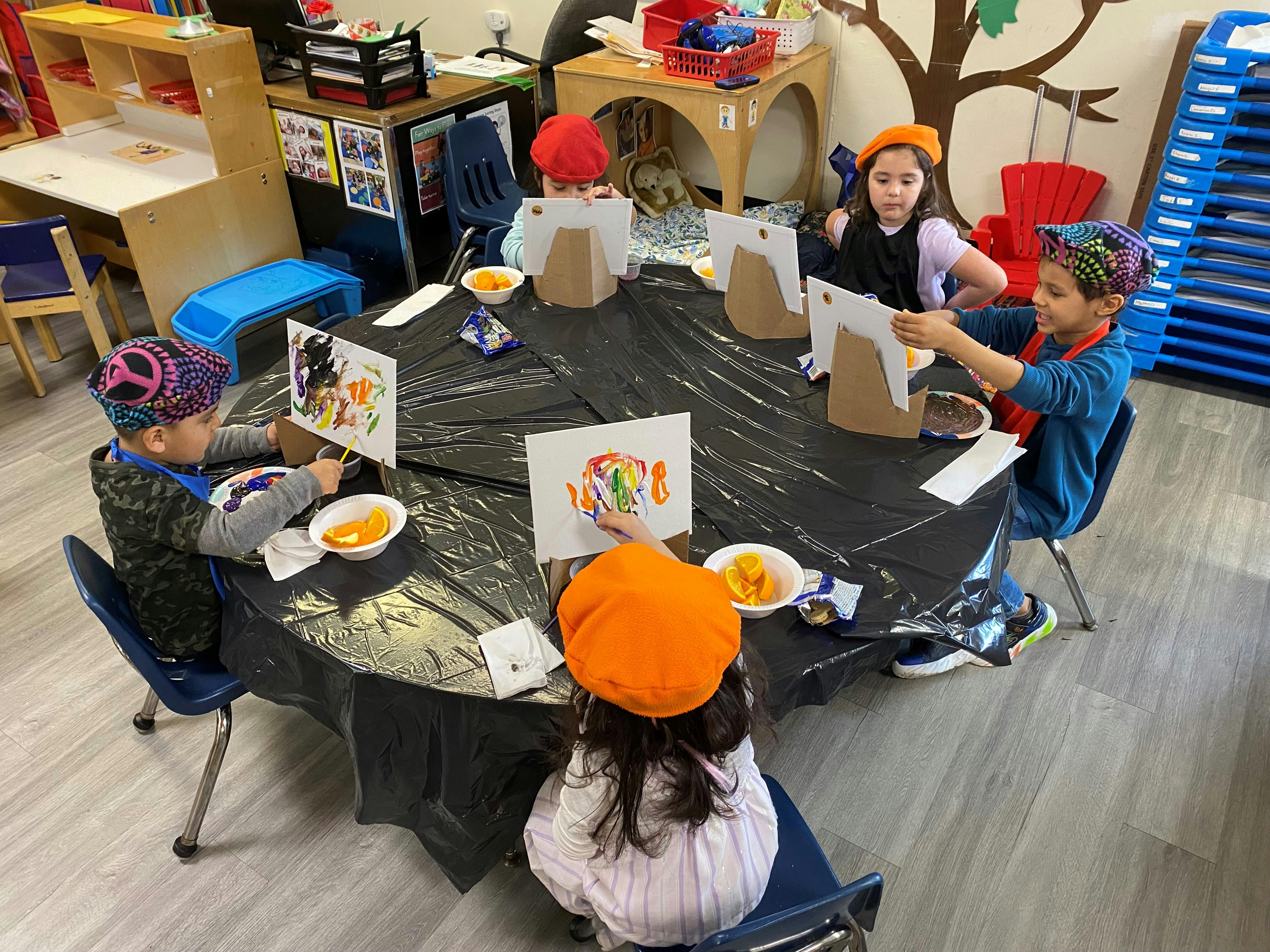 Children painting at a table in a classroom
