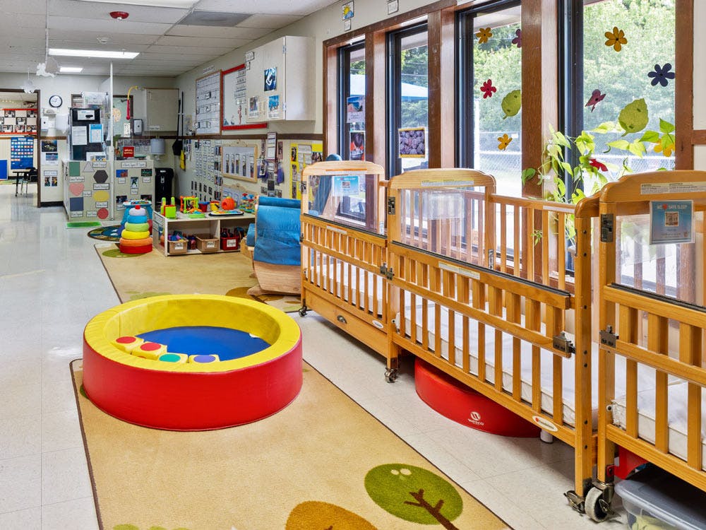 Cribs and play area in a daycare room